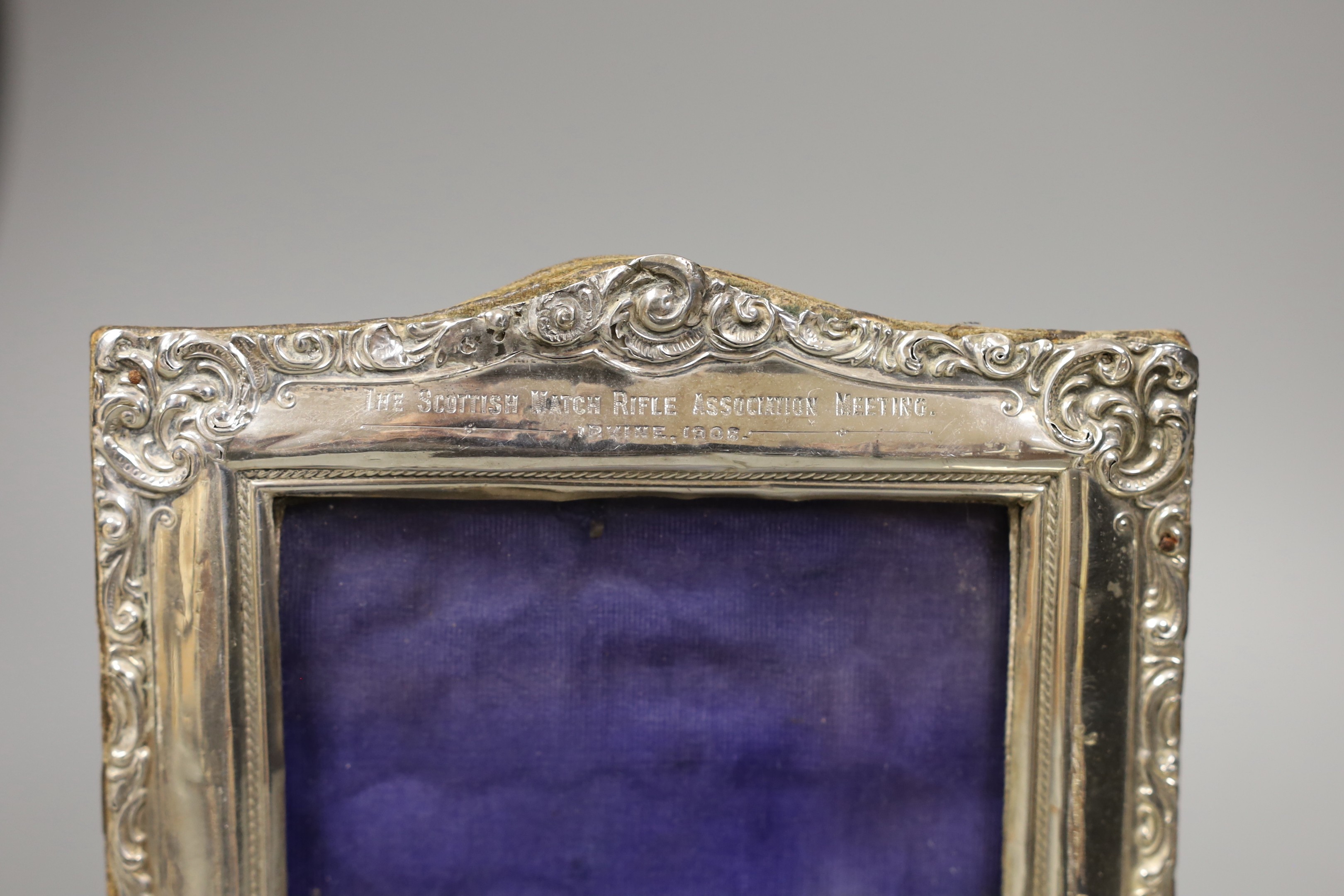 An Edwardian silver mounted photograph frame, with Scottish Match Rifle Association inscription, Boots Pure Drug Company, Birmingham, 1907, 19cm, together with a George V silver mounted capstan inkwell, with Bisley relat